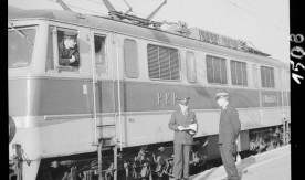 Lokomotywa elektryczna EU07. Dyżurny ruchu i kierownik pociągu przy odjeżdżającym pociągu na peronie